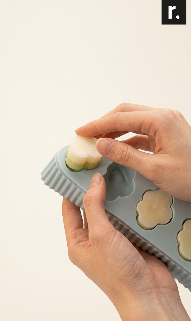 Hands releasing a treat from an example flexible silicone mold.