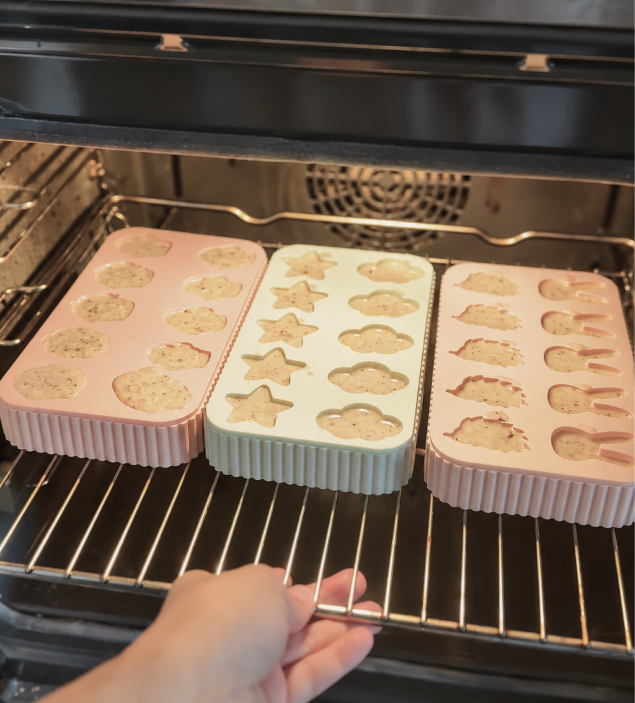 Example silicone treat molds filled with batter on an oven rack.