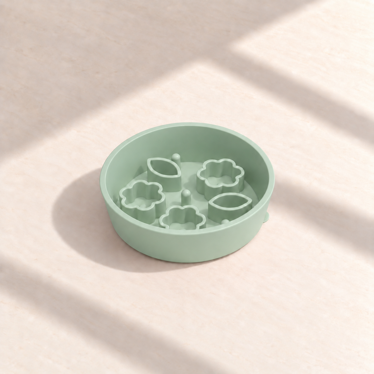 Green Flower + Leaf slow feeder bowl, 5.5-inch diameter, empty on a sunlit cream table