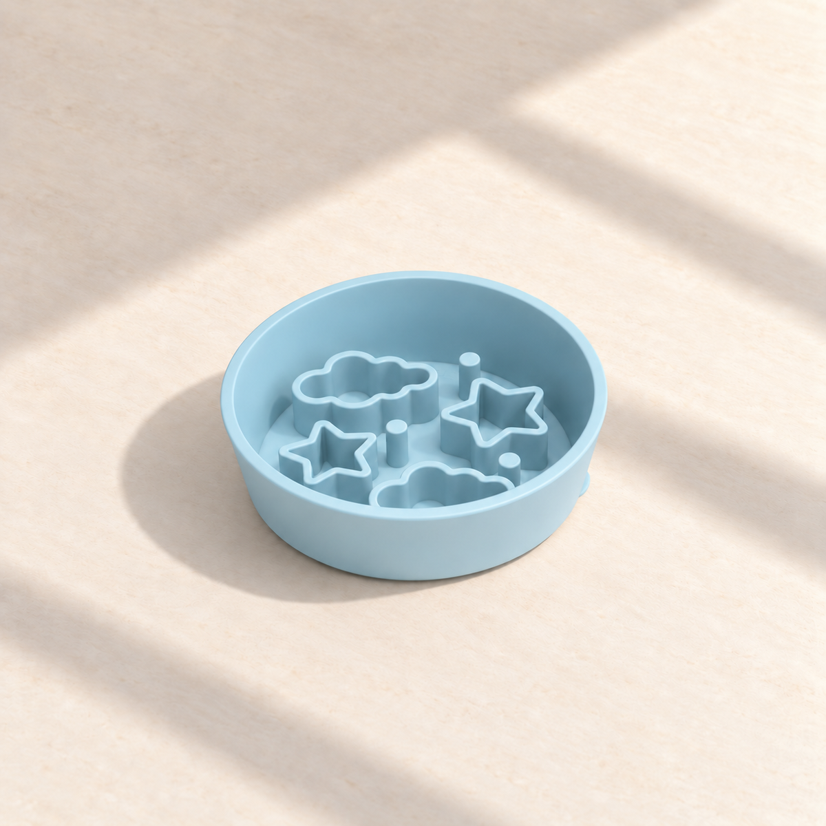 Blue Star + Cloud slow feeder bowl, 5.5-inch diameter, empty on a sunlit cream table